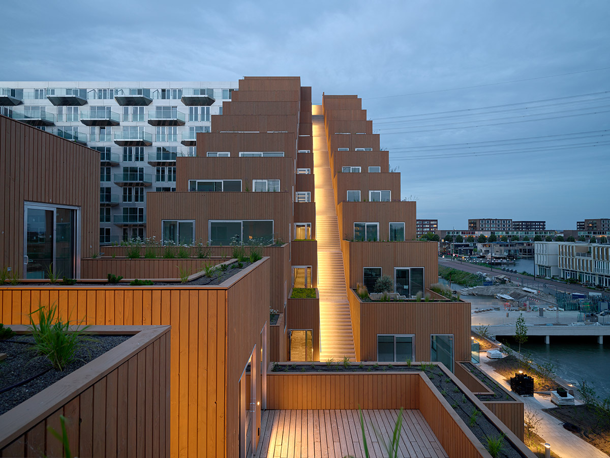 BIG and Barcode Architects built triangular housing block that its cantilevered corner forms gateway