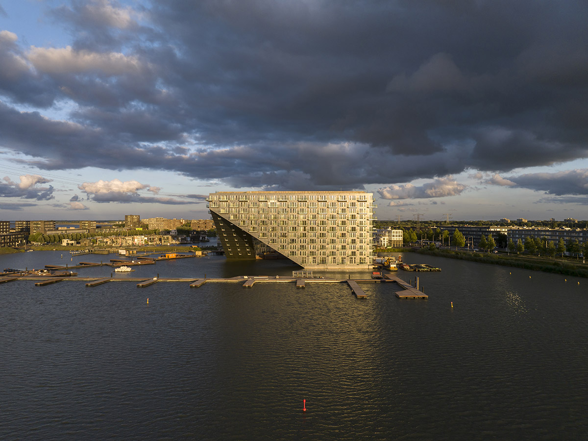 BIG and Barcode Architects built triangular housing block that its cantilevered corner forms gateway