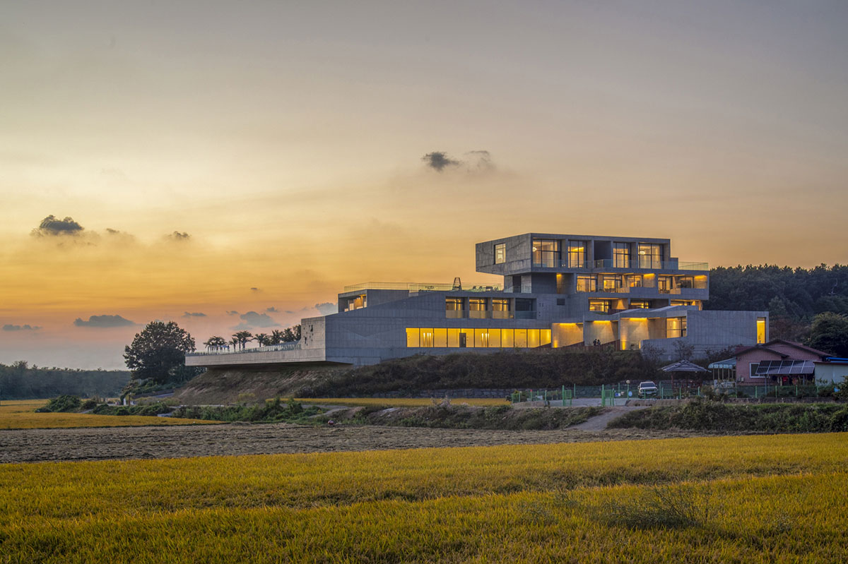 Elystay Resort is a striking horizontal concrete volume amidst scenic rural farmland in South Korea