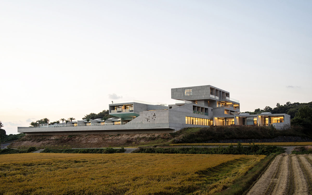 Elystay Resort is a striking horizontal concrete volume amidst scenic rural farmland in South Korea
