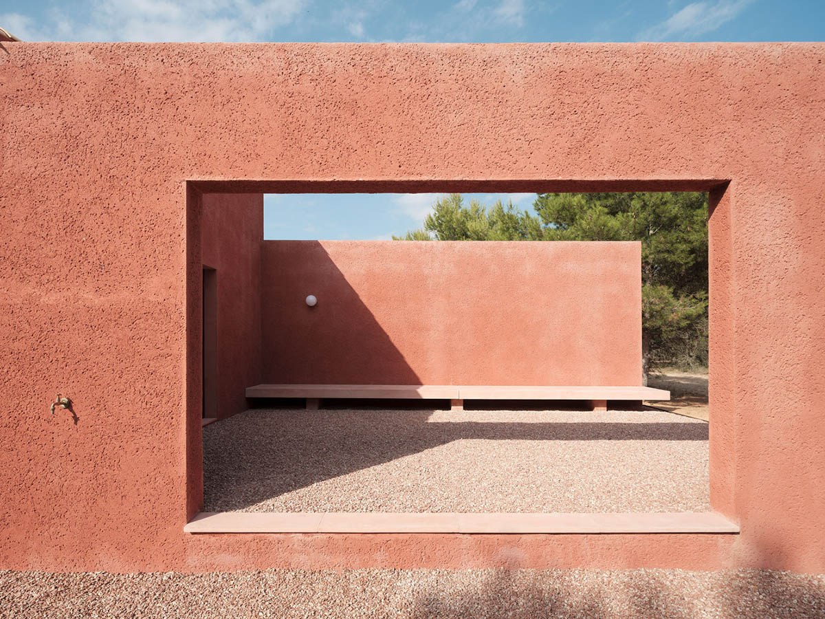 Large openings and reddish-colored façades mark this holiday home by Isla Architects in a rustic land