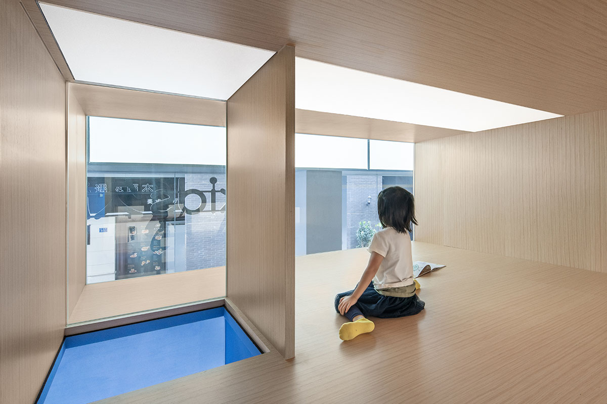 Crossboundaries designs blue sculptural spine as lively interface for Qkids English Center in China