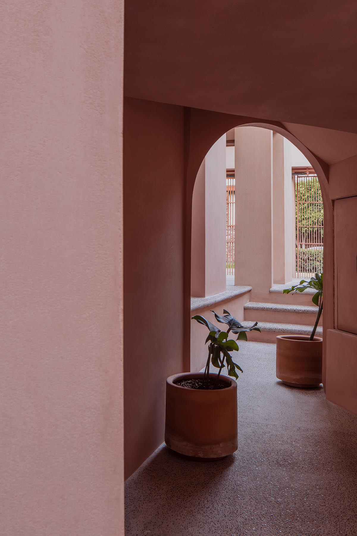 Heryco renovates Mexican apartment with layers of arches clad in pigmented lime stucco