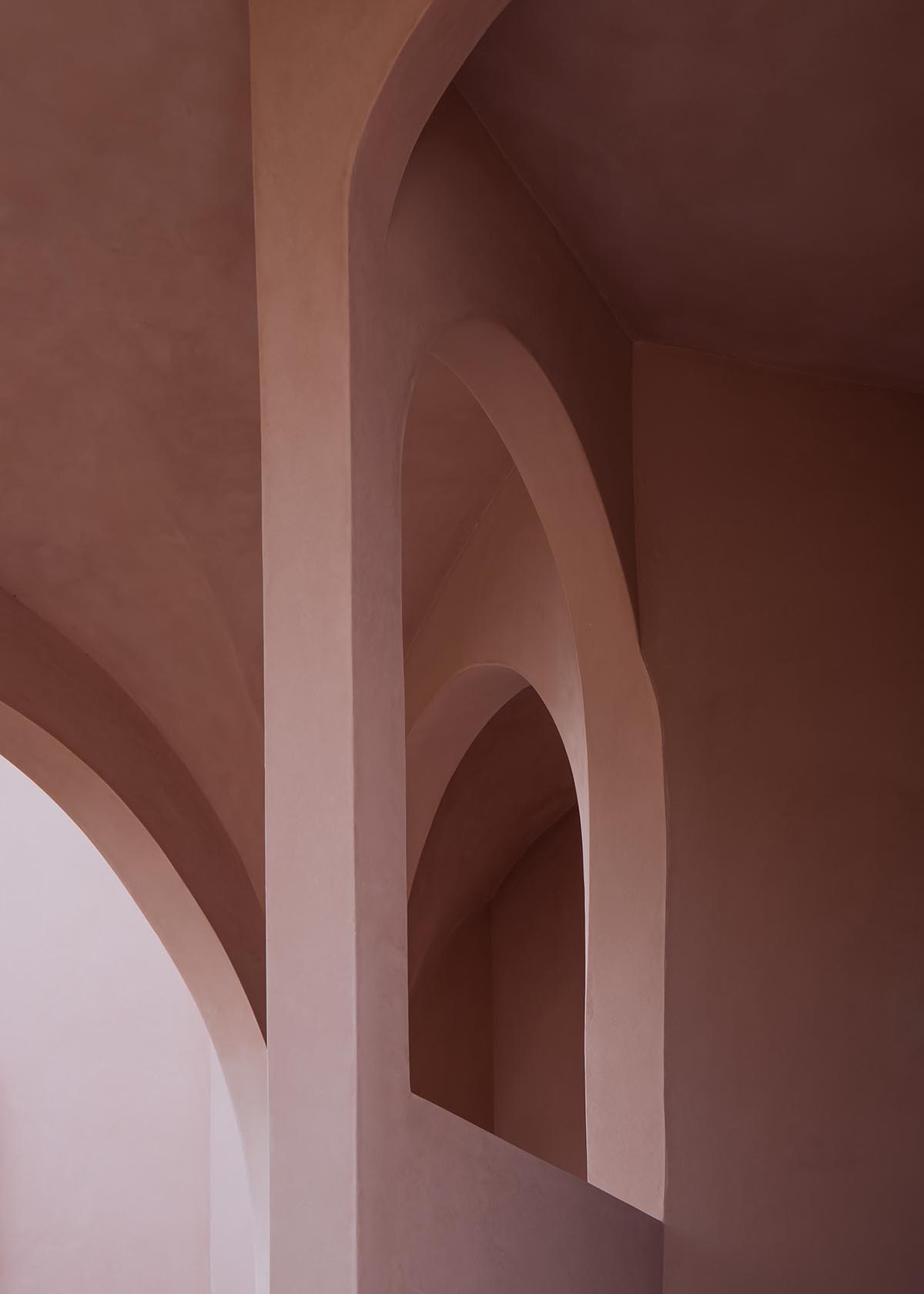 Heryco renovates Mexican apartment with layers of arches clad in pigmented lime stucco