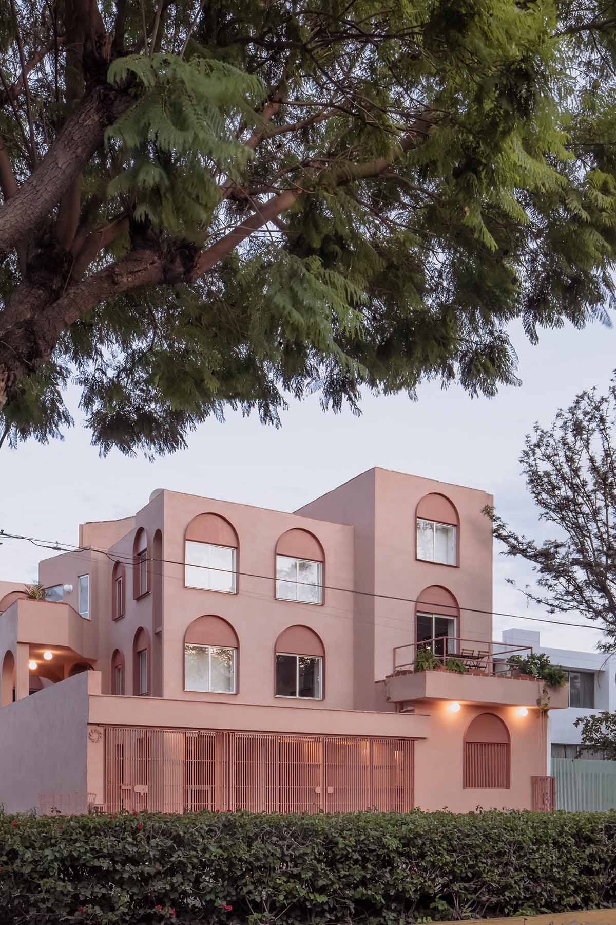 Heryco renovates Mexican apartment with layers of arches clad in pigmented lime stucco