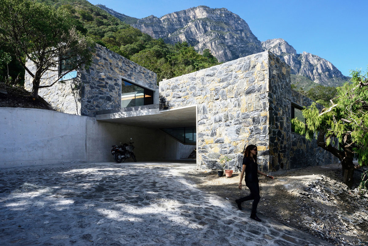 P+0 Arquitectura designs residence mixed with concrete and stone volumes on a complex terrain