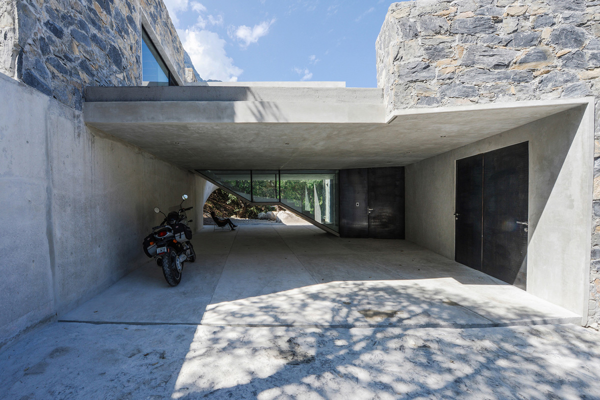 P+0 Arquitectura designs residence mixed with concrete and stone volumes on a complex terrain