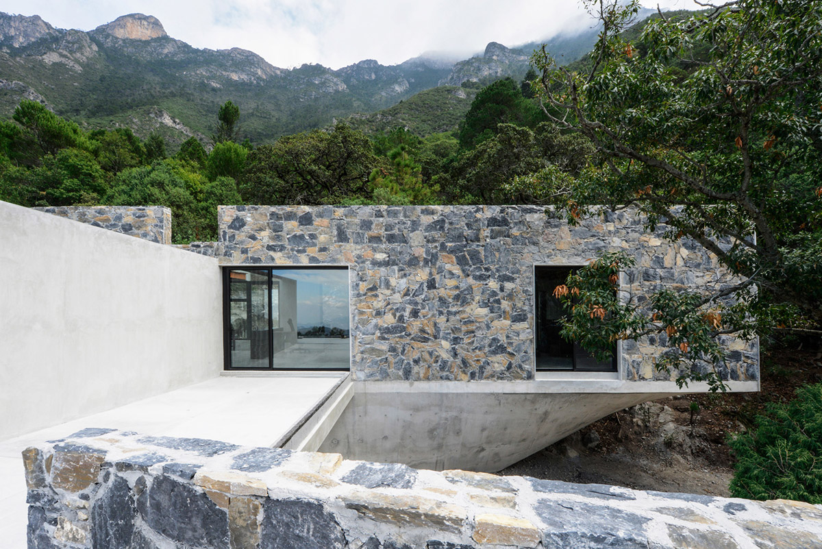 P+0 Arquitectura designs residence mixed with concrete and stone volumes on a complex terrain