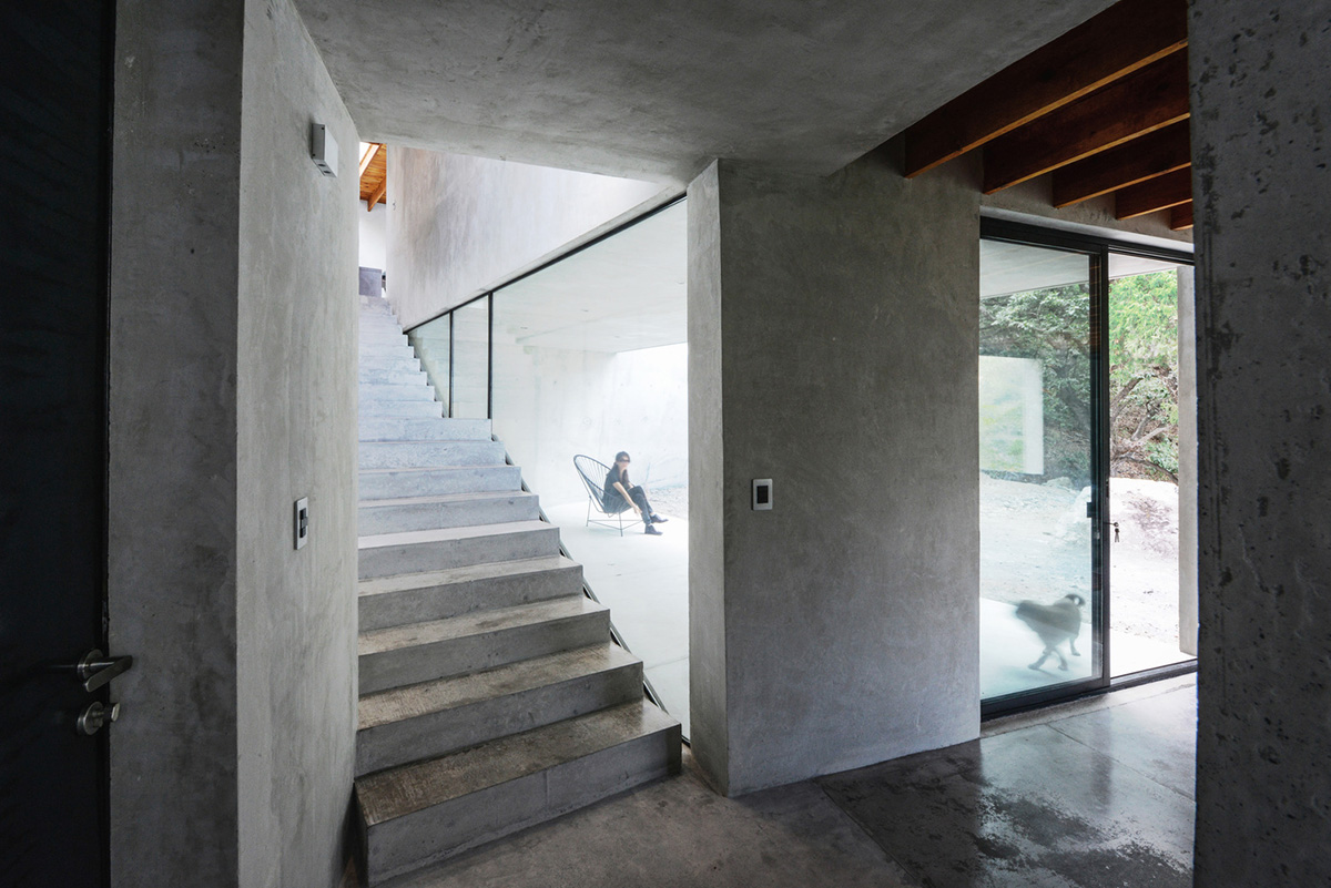 P+0 Arquitectura designs residence mixed with concrete and stone volumes on a complex terrain