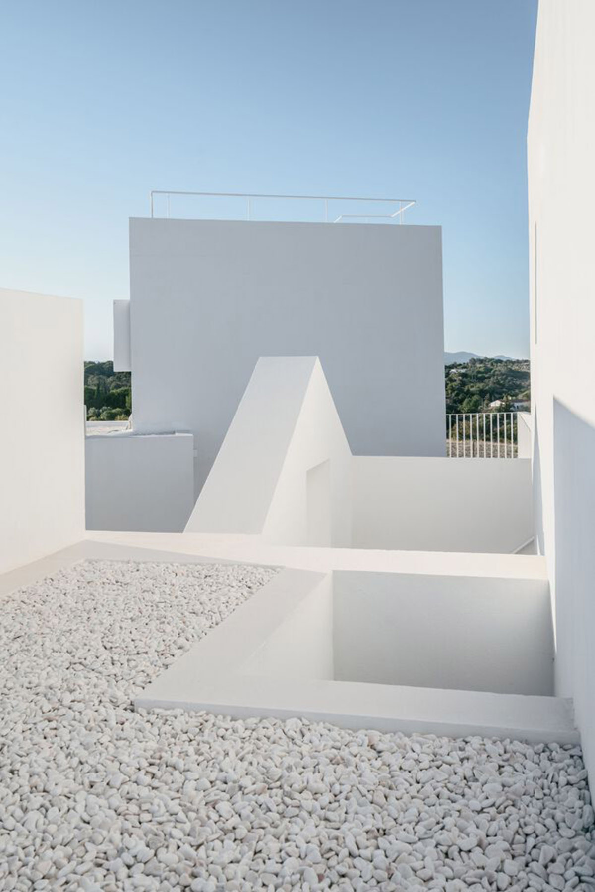 Portuguese holiday home is shaped around private patios and low-rise volumes in Algarve region