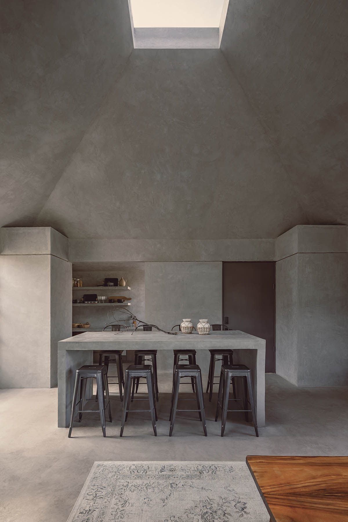 Rose-hued house by Práctica Arquitectura is topped with central roof to provide zenithal light 