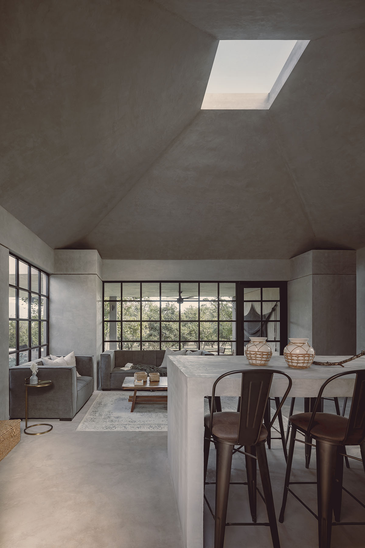 Rose-hued house by Práctica Arquitectura is topped with central roof to provide zenithal light 