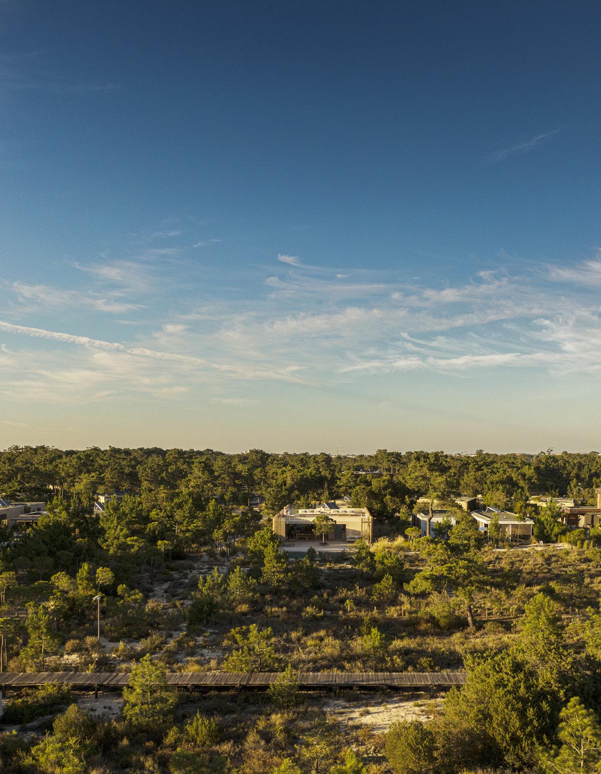 Palisade House is wrapped by a long palisade in fir wood to protect dunes in Troia, Portugal 