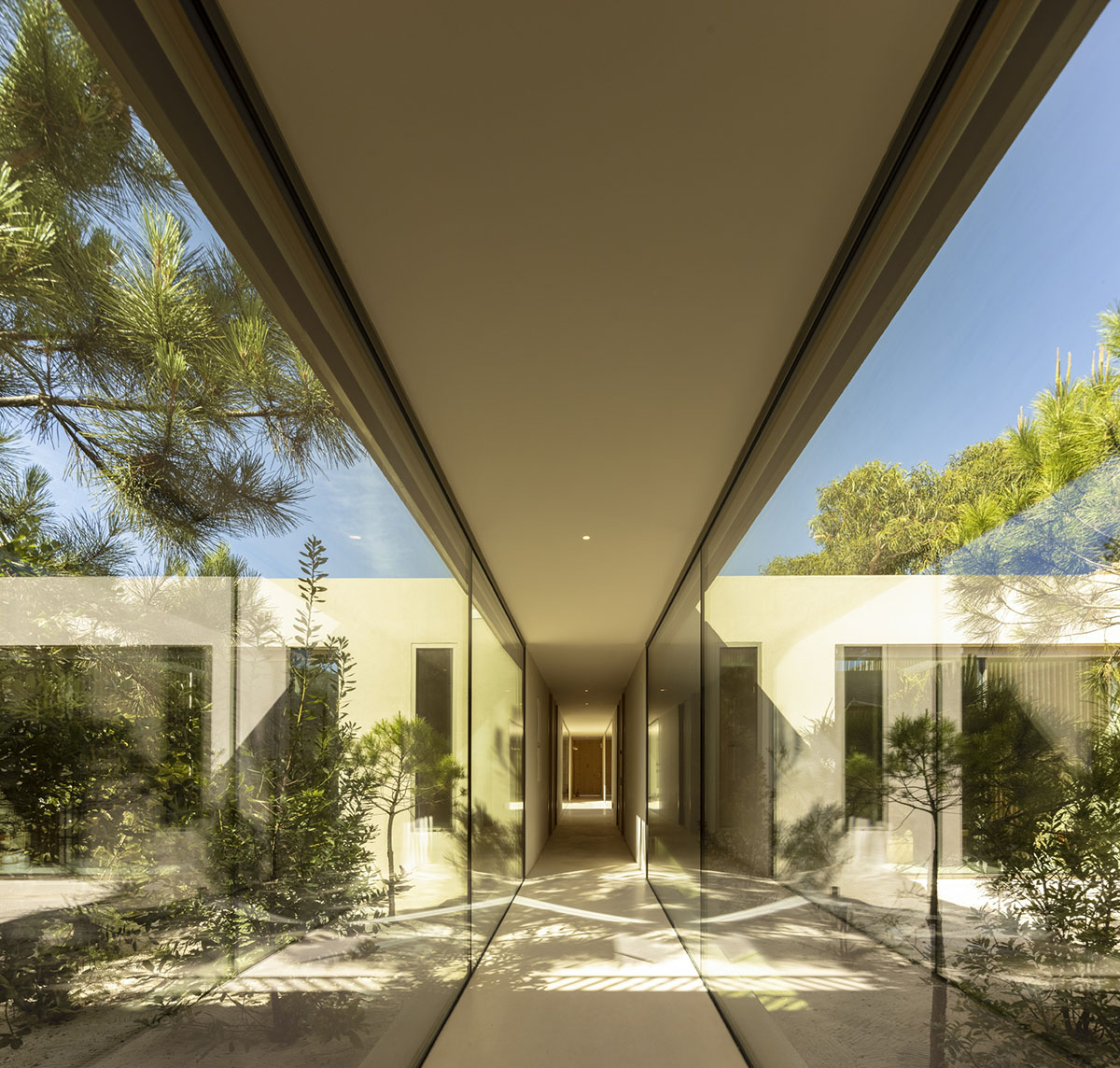 Palisade House is wrapped by a long palisade in fir wood to protect dunes in Troia, Portugal 