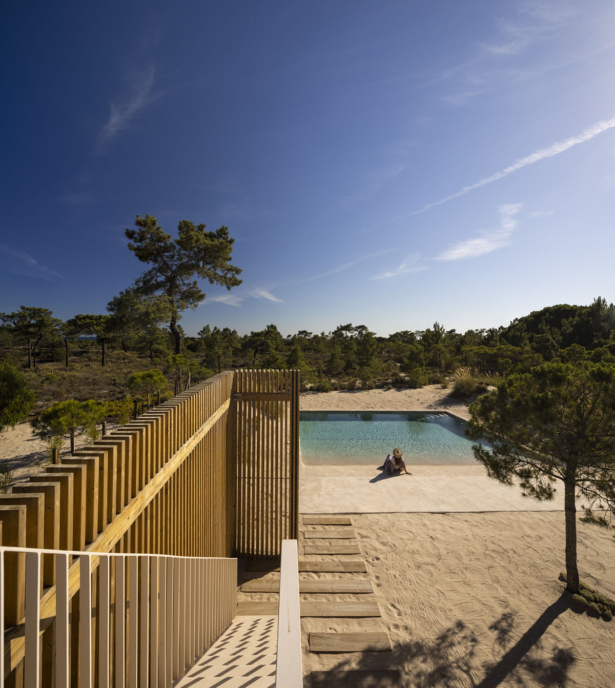 Palisade House is wrapped by a long palisade in fir wood to protect dunes in Troia, Portugal 