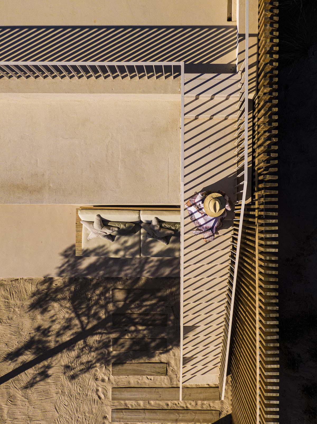 Palisade House is wrapped by a long palisade in fir wood to protect dunes in Troia, Portugal 