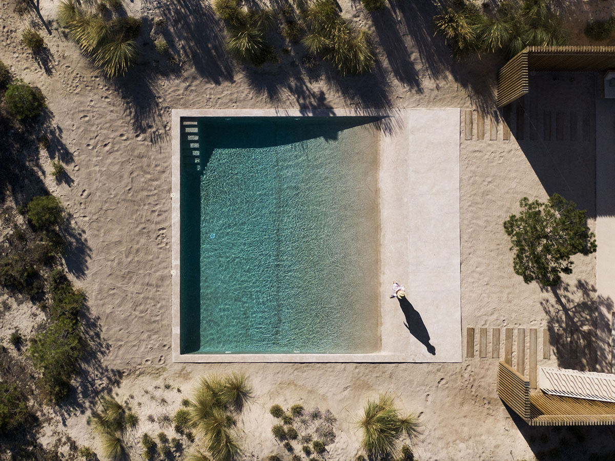Palisade House is wrapped by a long palisade in fir wood to protect dunes in Troia, Portugal 