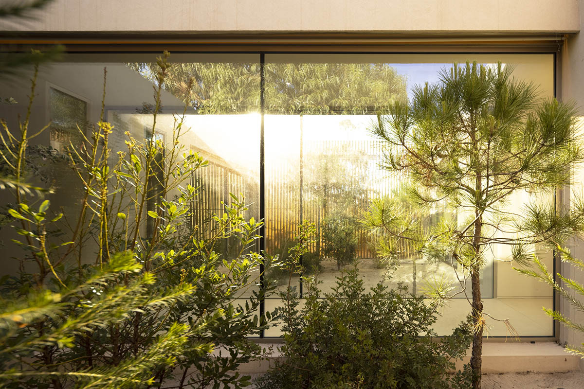 Palisade House is wrapped by a long palisade in fir wood to protect dunes in Troia, Portugal 