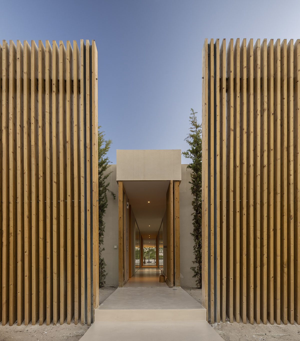 Palisade House is wrapped by a long palisade in fir wood to protect dunes in Troia, Portugal 