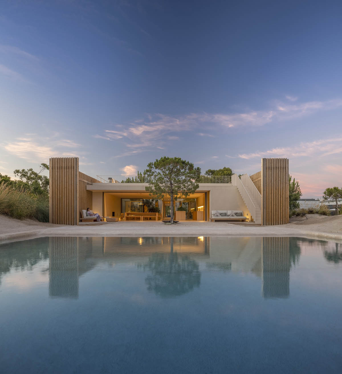 Palisade House is wrapped by a long palisade in fir wood to protect dunes in Troia, Portugal 