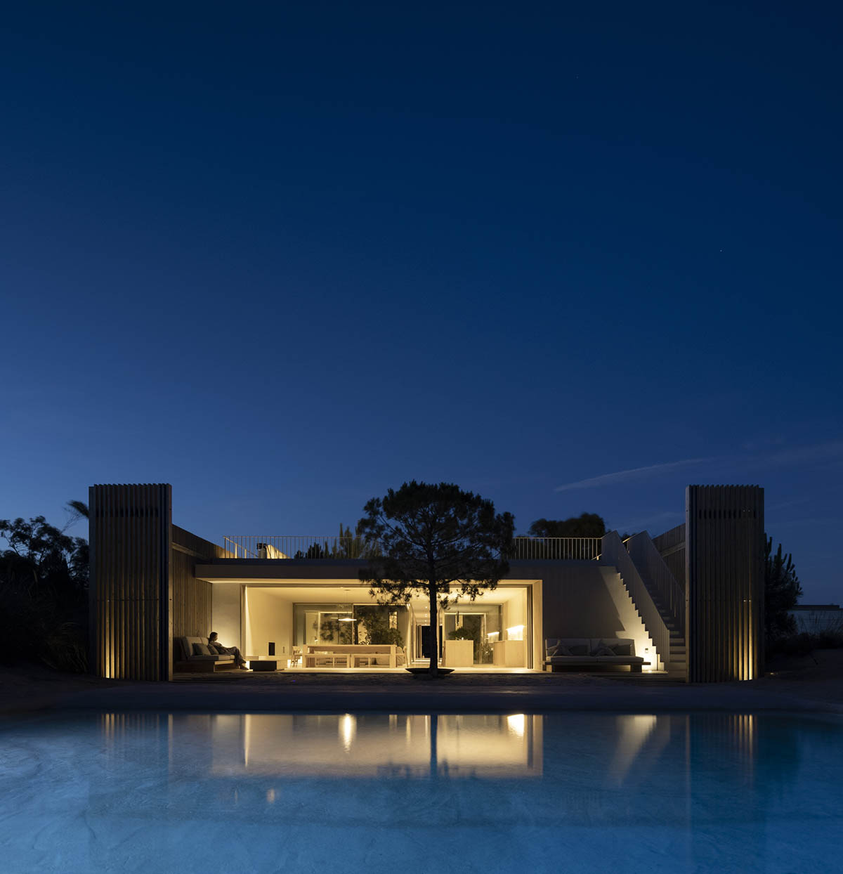 Palisade House is wrapped by a long palisade in fir wood to protect dunes in Troia, Portugal 