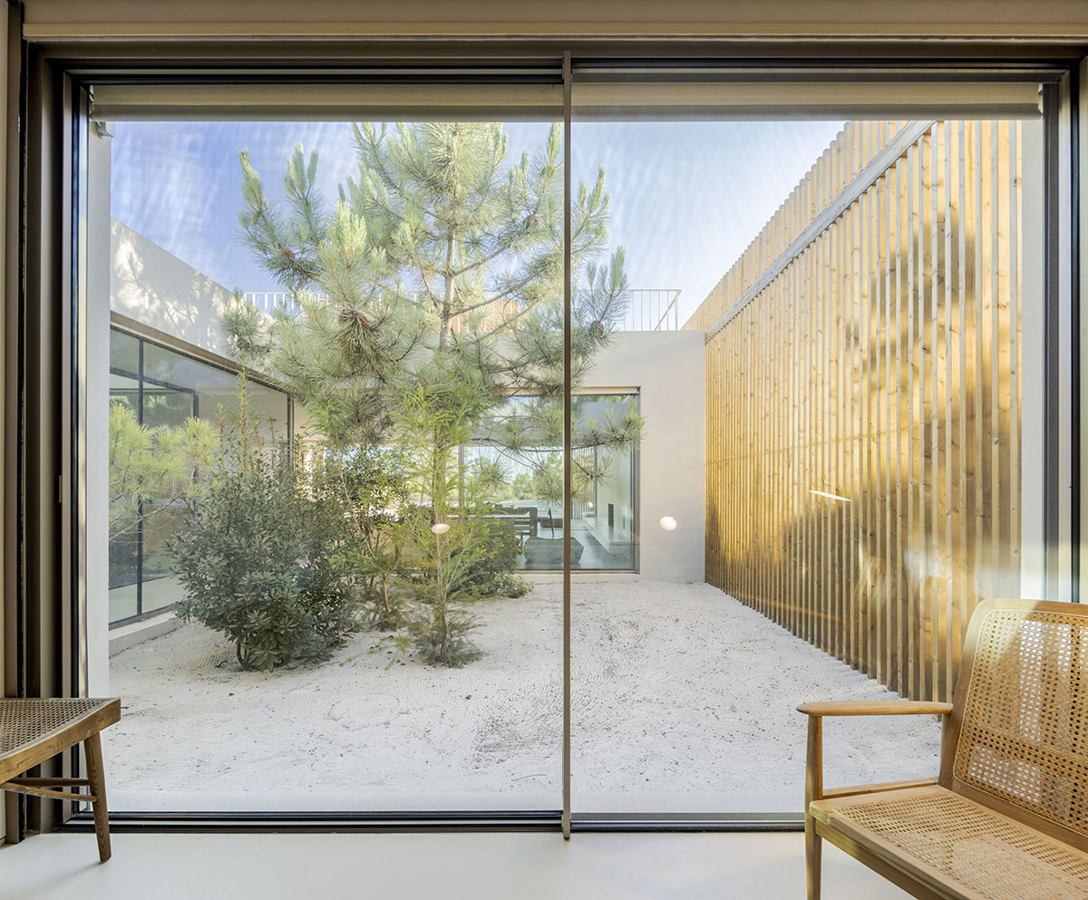 Palisade House is wrapped by a long palisade in fir wood to protect dunes in Troia, Portugal 