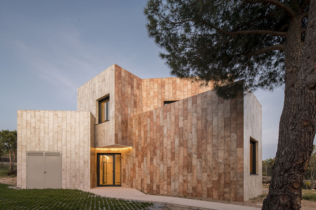 OOIIO Architecture plays with intersection of red ceramic-tiled volumes to create house in Madrid