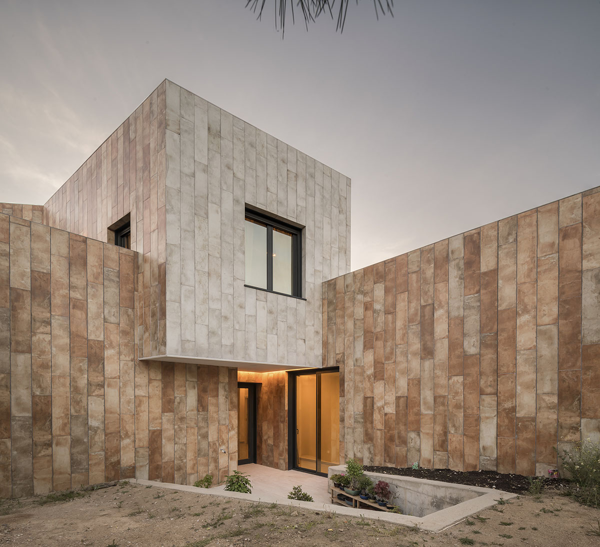 OOIIO Architecture plays with intersection of red ceramic-tiled volumes to create house in Madrid