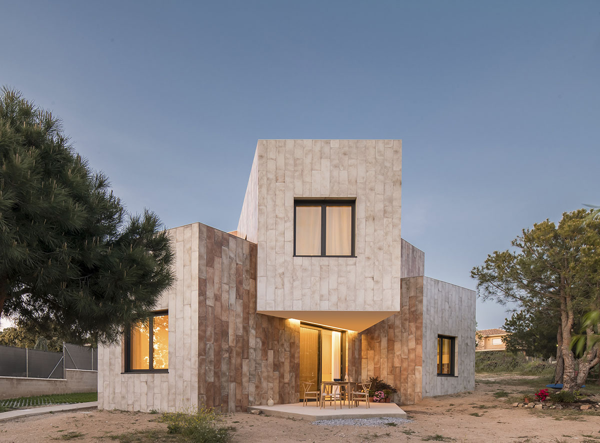 OOIIO Architecture plays with intersection of red ceramic-tiled volumes to create house in Madrid