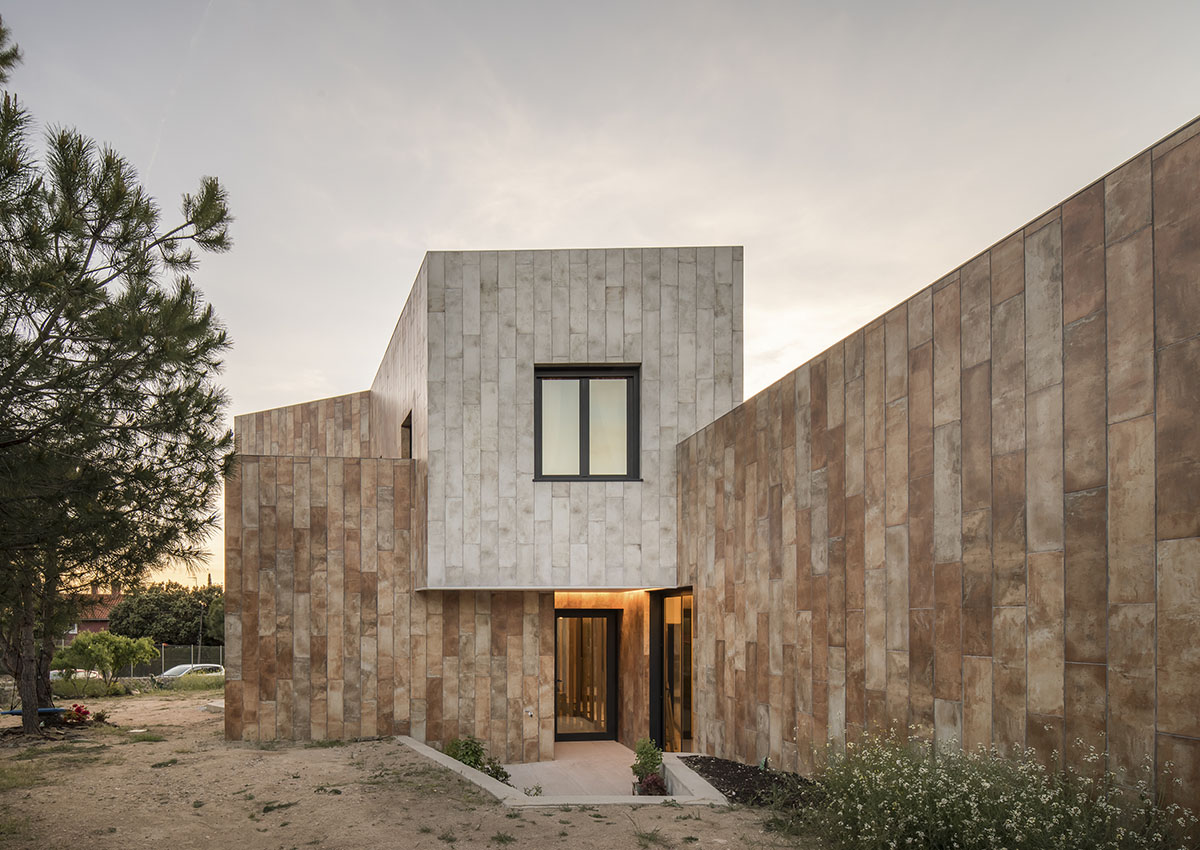 OOIIO Architecture plays with intersection of red ceramic-tiled volumes to create house in Madrid
