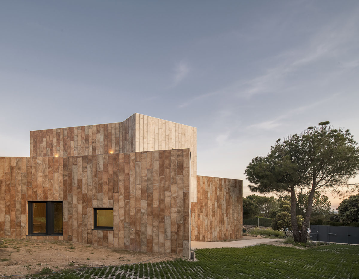 OOIIO Architecture plays with intersection of red ceramic-tiled volumes to create house in Madrid