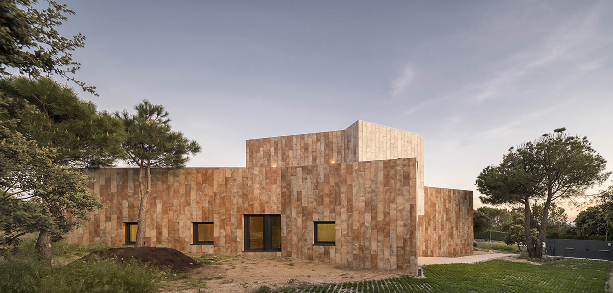 OOIIO Architecture plays with intersection of red ceramic-tiled volumes to create house in Madrid