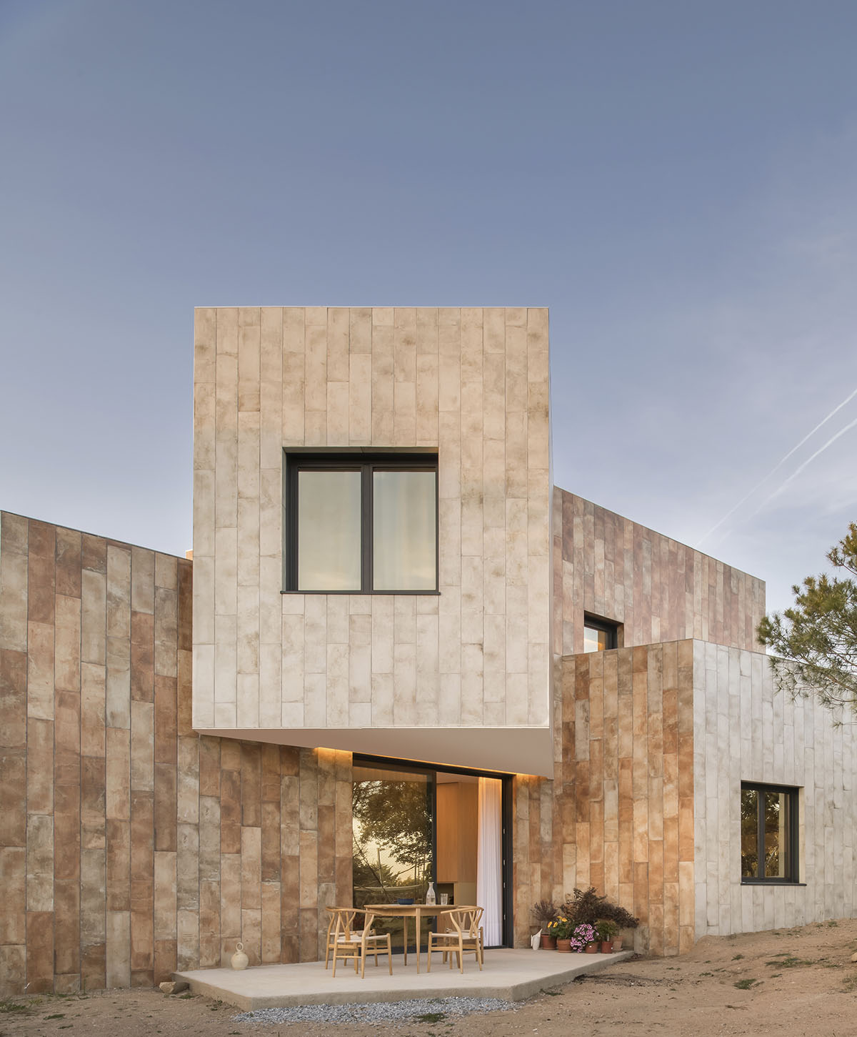 OOIIO Architecture plays with intersection of red ceramic-tiled volumes to create house in Madrid