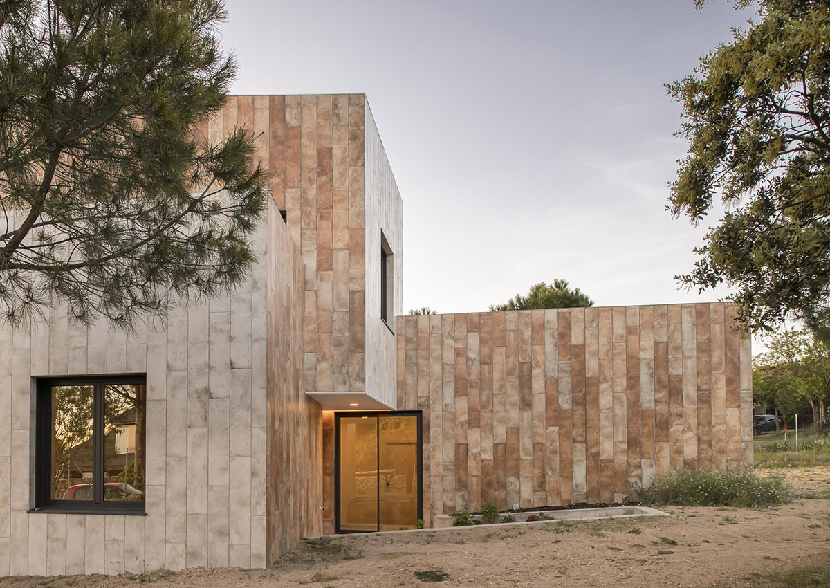 OOIIO Architecture plays with intersection of red ceramic-tiled volumes to create house in Madrid