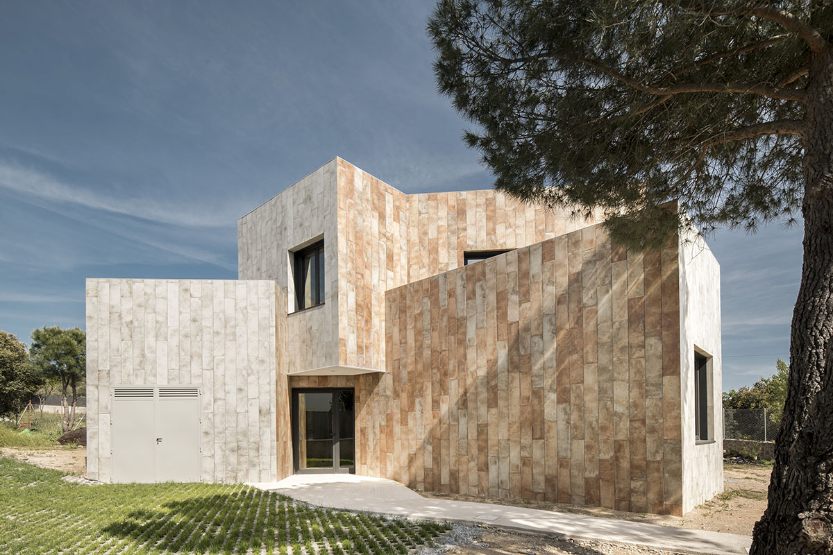 OOIIO Architecture plays with intersection of red ceramic-tiled volumes to create house in Madrid