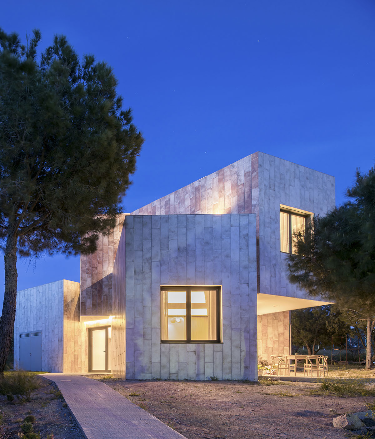 OOIIO Architecture plays with intersection of red ceramic-tiled volumes to create house in Madrid