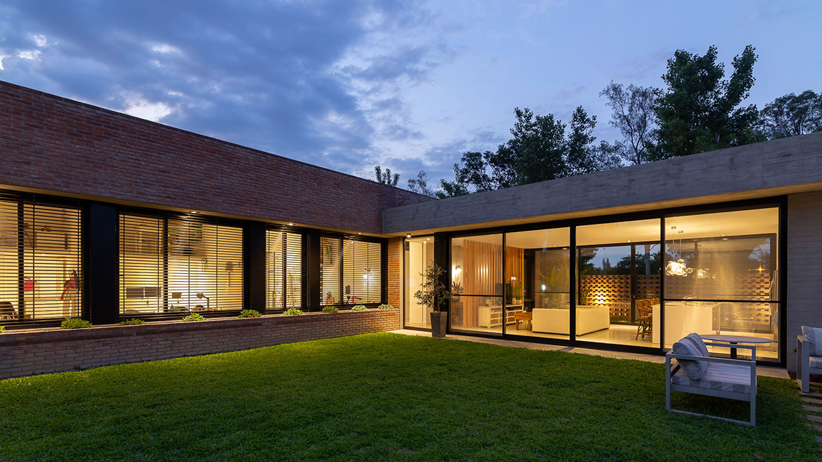 Nómade Arquitectura creates urban filter with large interlocked brick wall for house in Argentina