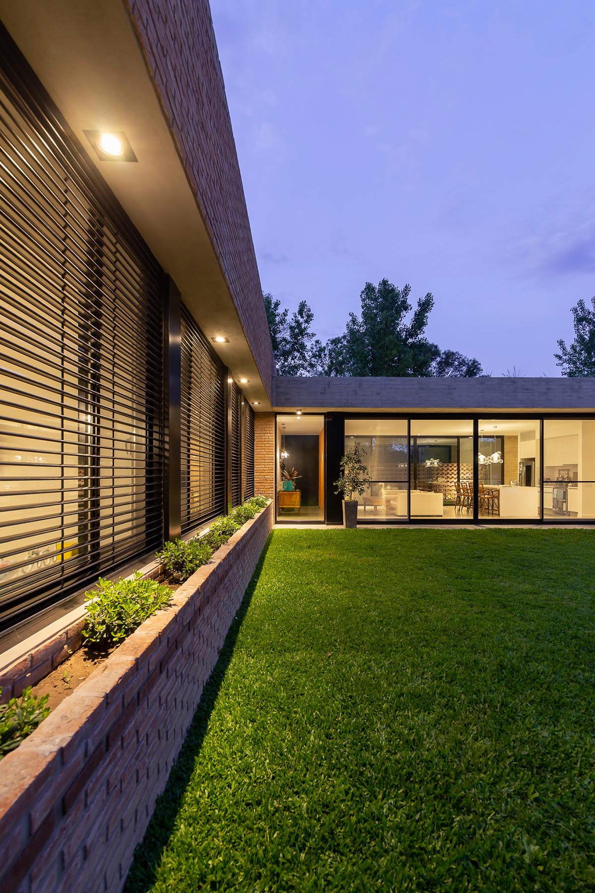 Nómade Arquitectura creates urban filter with large interlocked brick wall for house in Argentina
