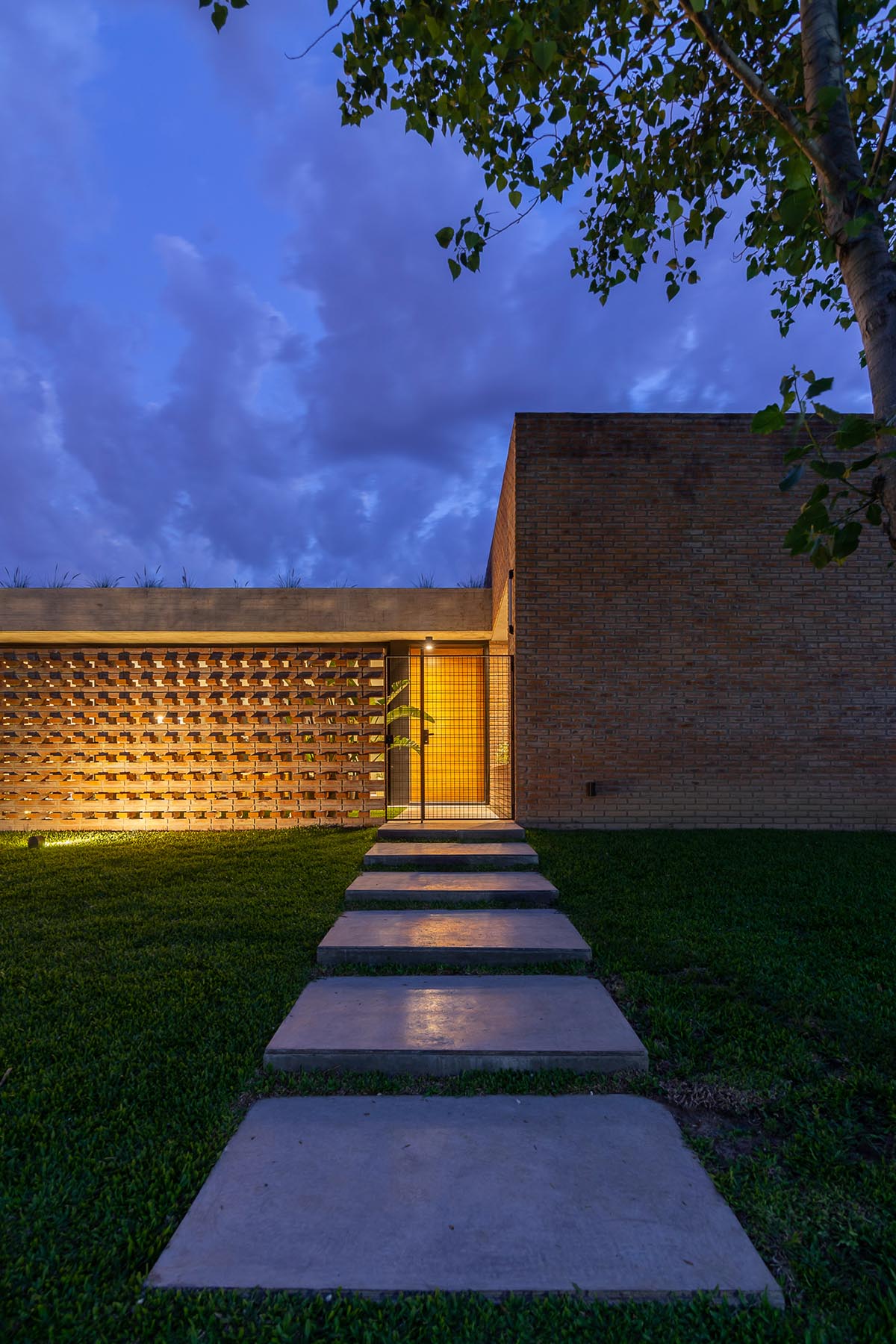 Nómade Arquitectura creates urban filter with large interlocked brick wall for house in Argentina