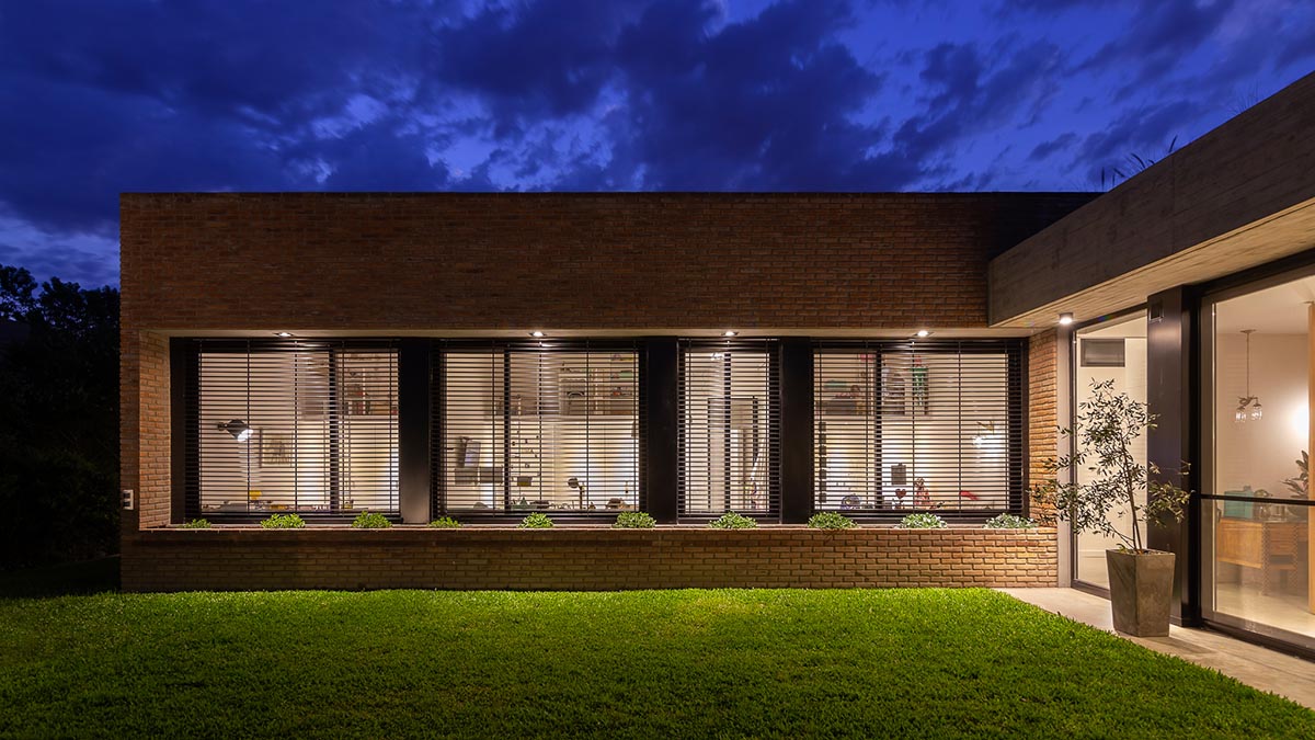 Nómade Arquitectura creates urban filter with large interlocked brick wall for house in Argentina