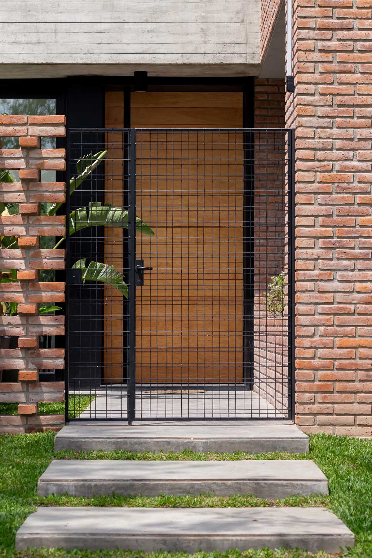 Nómade Arquitectura creates urban filter with large interlocked brick wall for house in Argentina