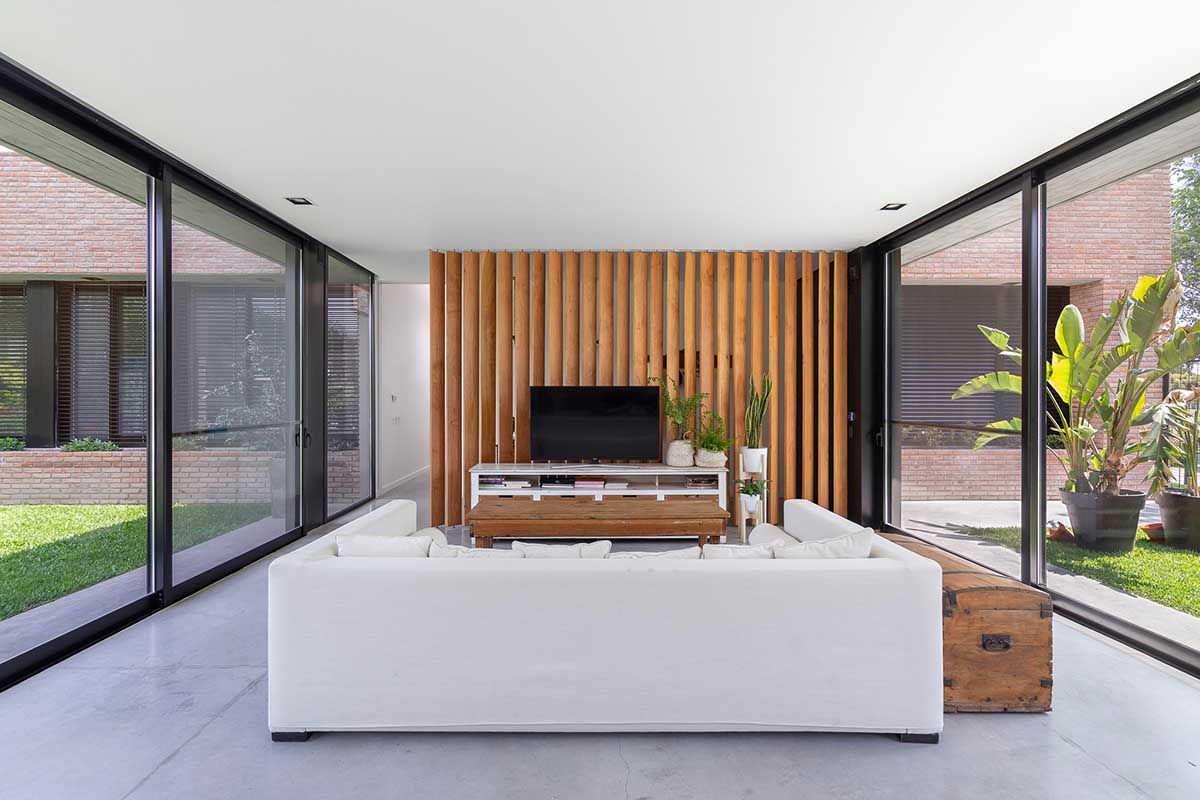 Nómade Arquitectura creates urban filter with large interlocked brick wall for house in Argentina