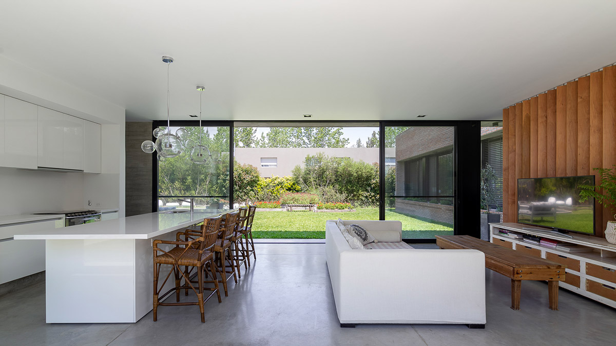 Nómade Arquitectura creates urban filter with large interlocked brick wall for house in Argentina