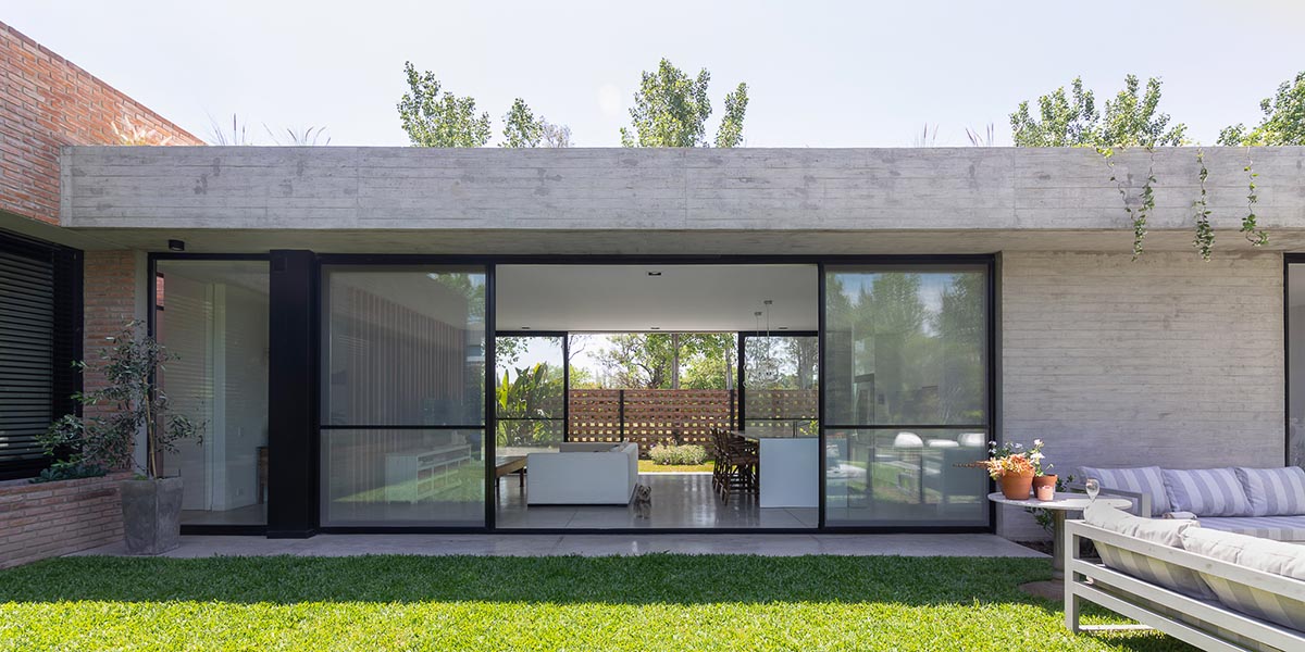 Nómade Arquitectura creates urban filter with large interlocked brick wall for house in Argentina