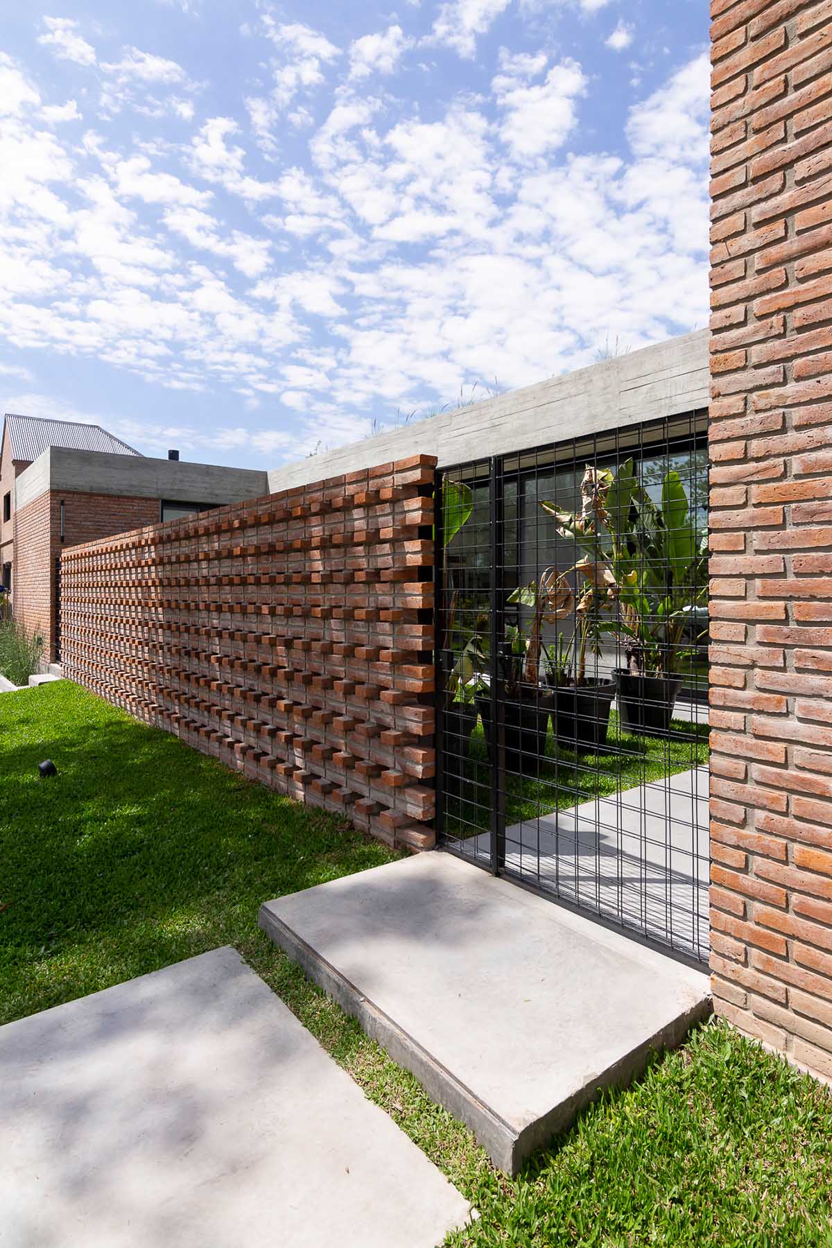 Nómade Arquitectura creates urban filter with large interlocked brick wall for house in Argentina