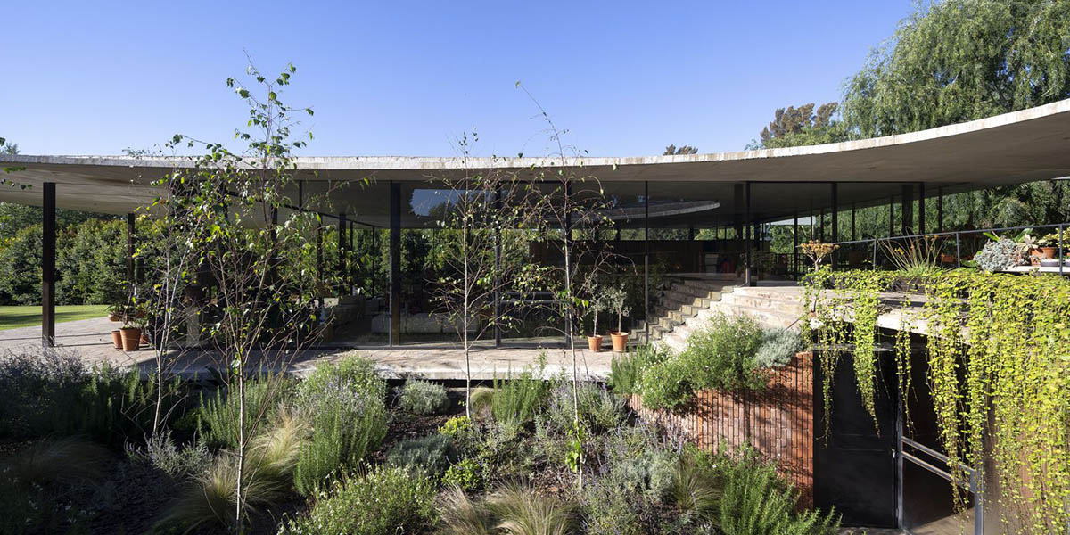 Slender, curvaceous canopy wraps organically-shaped Rita House in Argentinean forest