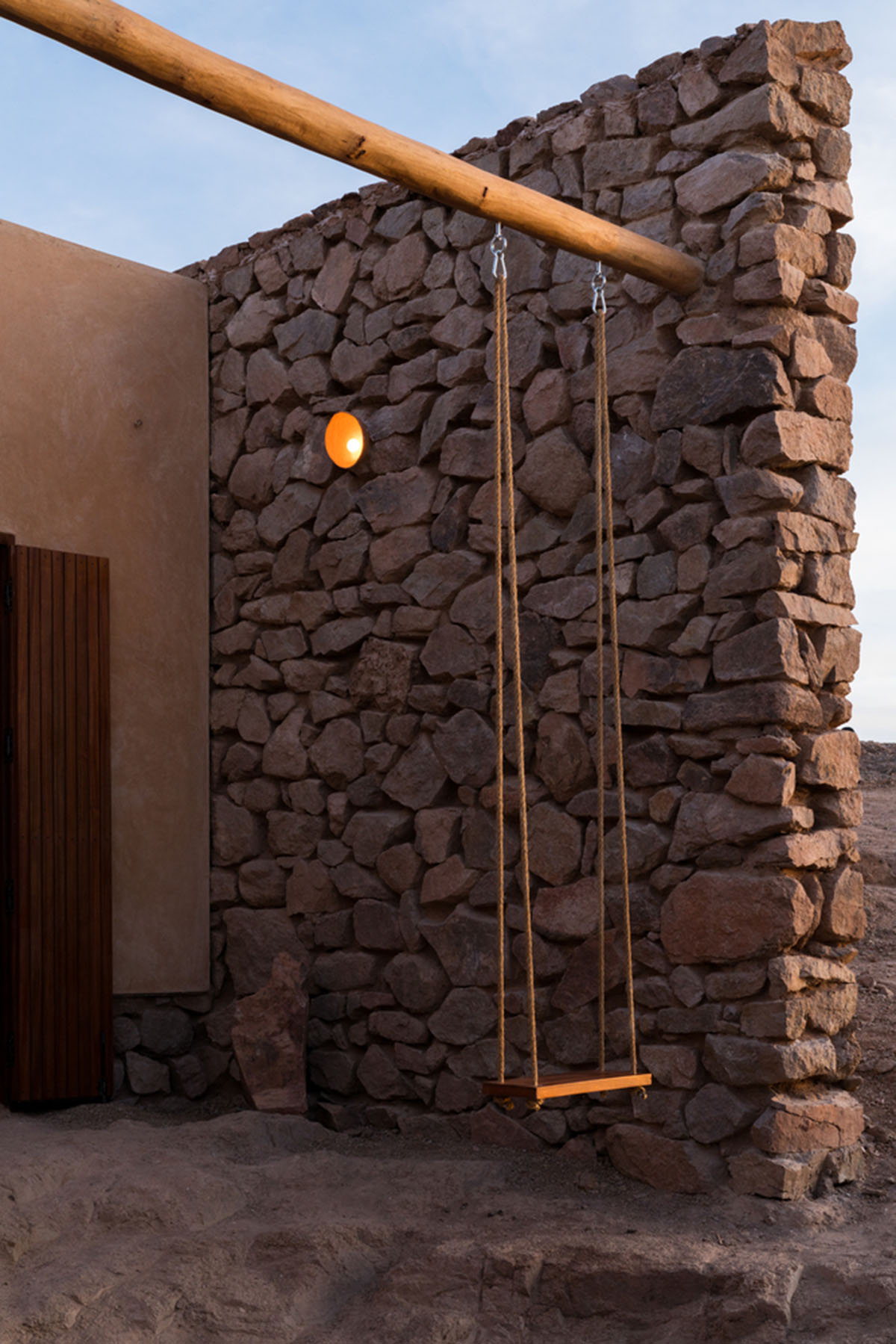 Two elongated walls made of granite rocks and earth form this women's house in a village of Morocco