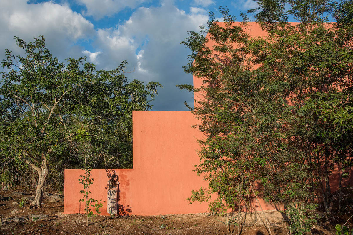 TACO completes mini vacation house covered with reddish artisanal paint in a wild nature of Mexico