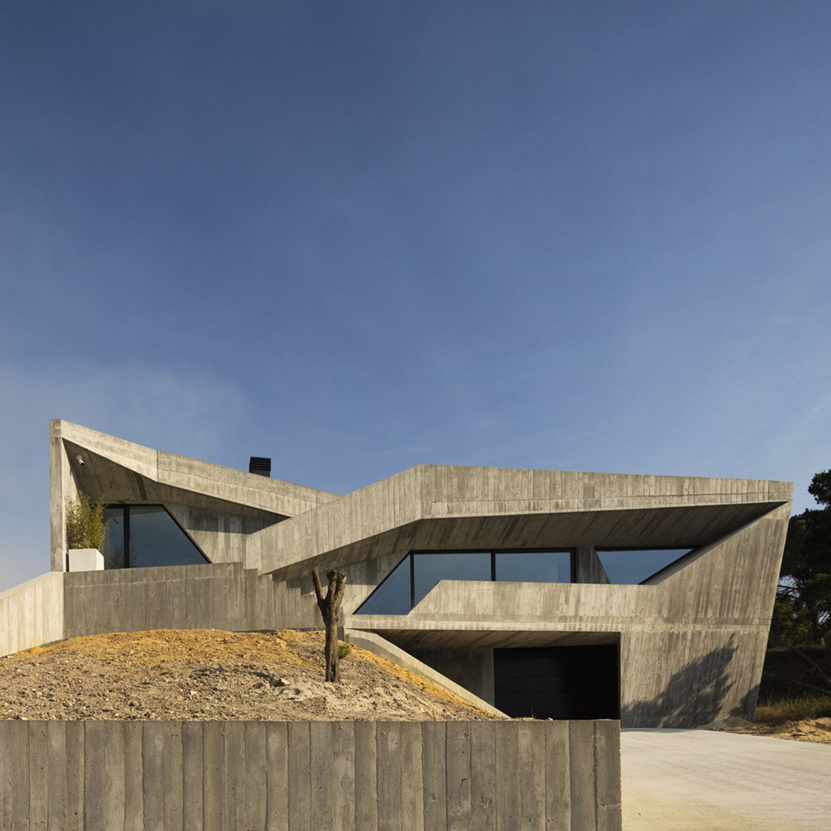 Contaminar Arquitectos built cave-like house from irregular walls inspired by rocky topography