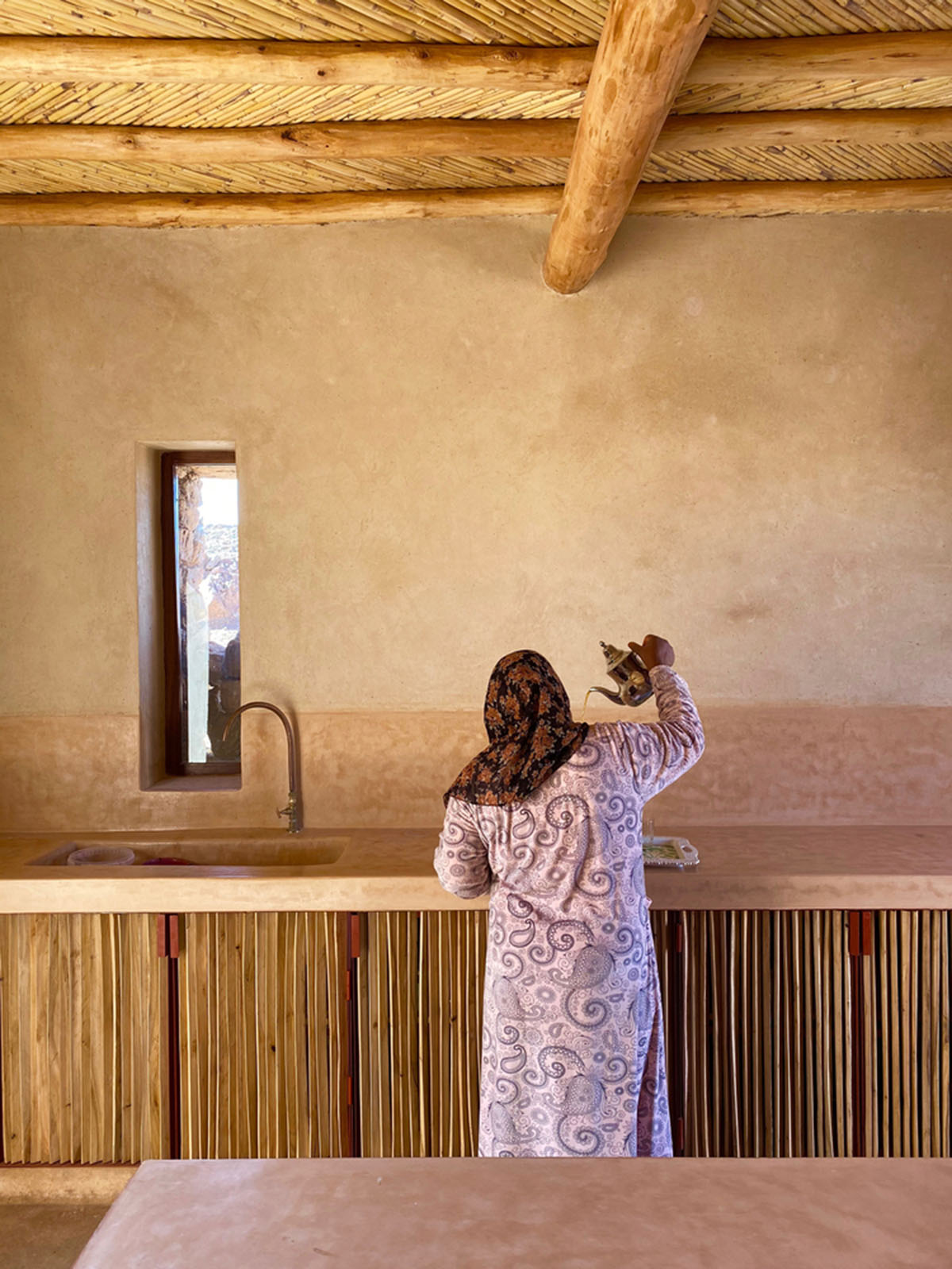 Two elongated walls made of granite rocks and earth form this women's house in a village of Morocco